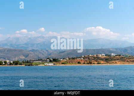 Chania, Crete, Greece. June 2019. The coastal landscape of Chania northern Crete showing hotels and homes with a backdrop of mountains Stock Photo