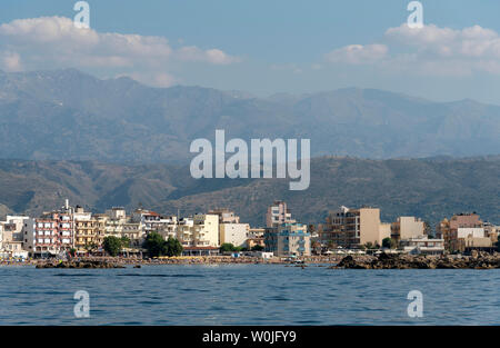 Chania, Crete, Greece. June 2019. The coastal landscape of Chania northern Crete showing hotels and homes with a backdrop of mountains Stock Photo