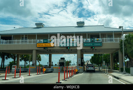 Toll station and barriers on a motorway with a vehicle stopped making payment of the toll fee at the booths Stock Photo