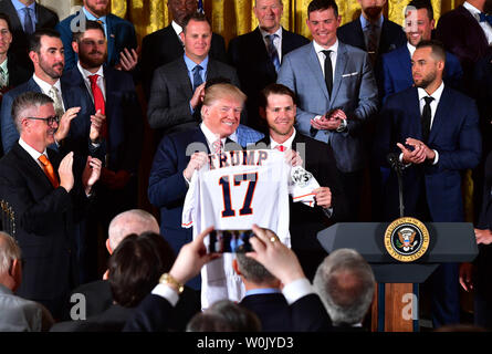 President Donald Trump (L) receives a custom jersey from Houston Astros  outfielder Josh Reddick as Trump welcomes the 2017 World Series Champion  Houston Astros to the White House on March 12, 2018