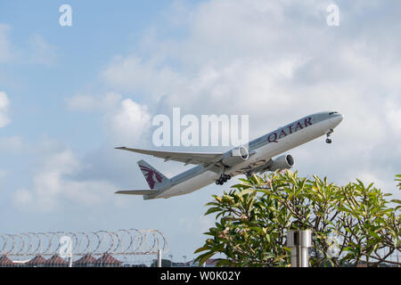 DENPASAR,BALI/INDONESIA-JUNE 08 2019: Qatar airline aeroplane is flying from Ngurah Rai International Airport Bali, when the sky is cloudy grey, with Stock Photo