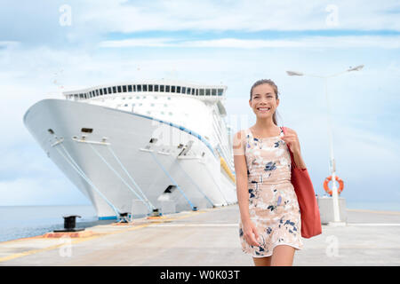 Cruise ship travel going shopping in port on travel cruise vacation at sea. Happy mixed race Asian Chinese Caucasian woman in dress by luxury cruise liner boat. Stock Photo