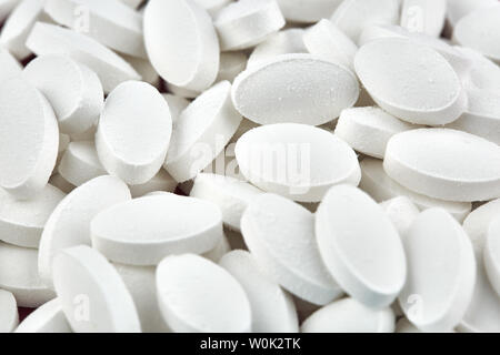 Close-up photo of small white pills. Medicine. Stock Photo