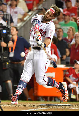 Washington Nationals' Bryce Harper (L) of the National League is awarded  the trophy by his father Ron Harper after winning the 2018 Home Run Derby  at Nationals Park in Washington, D.C. on