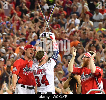 Washington Nationals Bryce Harper holds up the trophy after winning the the  Major League Baseball Home Run Derby, Monday, July 16, 2018, in Washington.  (AP Photo/Alex Brandon)