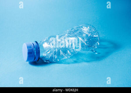 Used disposable plastic bottle on blue background. Eco concept image. Stock Photo