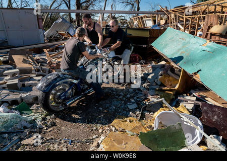 Ryan Jenkins sits on and guides his dad RJ Juncker's $32,000 'Big Dog Mastiff' bike, right, with the help of Paul Macklin out from under the debris after Hurricane Michael slammed into Panama City October 12, 2018. Michael hit the Florida coast October 10 as a Category 4 near Mexico Beach as the most powerful storm to hit the southern US state in more than a century. Michael made landfall around 1:00 pm Eastern time (1700 GMT), the National Hurricane Center said.    Photo by Ken Cedeno/UPI Stock Photo