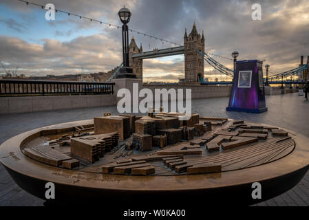 LONDON, ENGLAND, DECEMBER 10th, 2018: Tower Bridge in London, United Kingdom. Sunrise with beautiful clouds and model of nearby tourist area. English Stock Photo