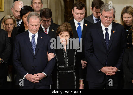 Former President George W. Bush (L) former First Lady Laura Bush (C) and former Florida Governor Jeb Bush pray as President George H. W. Bush lies in state at the U.S. Capitol Rotunda, in Washington, D.C. on December 3, 2018. The late President will lie in state until 7am Wednesday morning followed by a sate funeral at the National Cathedral. Photo by Kevin Dietsch/UPI Stock Photo