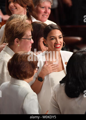 Alexandria Ocasio-Cortez (D-NY) (C) joins other congresswomen wearing white in honor of women's suffrage, as they arrive before President Donald Trump delivers his State of the Union address to a joint session of Congress in the House Chamber of the U.S. Capitol in Washington, DC on February 5, 2019.    Photo by  Kevin Dietsch/UPI Stock Photo