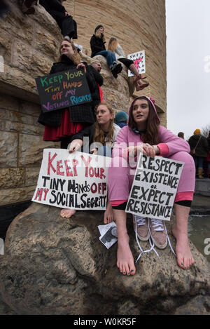 Alyson Heimer (L), 31, of Newhaven CT., Lucy Buckman, 21, and Annliease DeVita,19, both from DC. view the massive crowd from the grounds of the American Indian Museum during the Women's March on Washington to protest the election of Donald Trump as President of the United States January 21, 2017 in Washington D.C..    Photo by Ken Cedeno/UPI Stock Photo