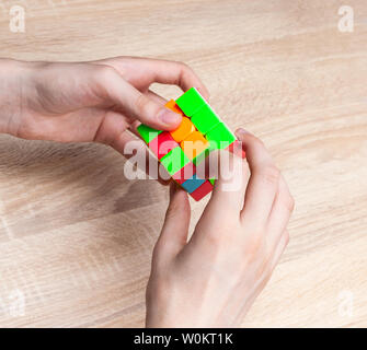 Boy holding Rubik's cube and playing with it. Rubik's cube in child's hands, closeup. Stock Photo