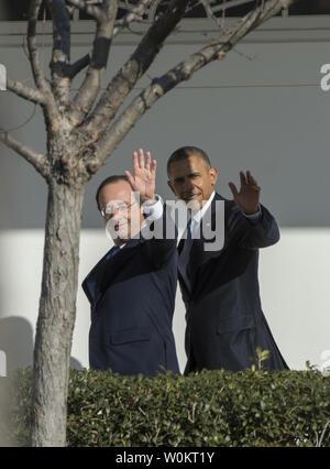 U.S. President Barack Obama and French President Francois Hollande (L) wave as they make their way along the Colonnade to the Oval Office after the official State Visit arrival ceremony on the South Lawn of the White House in Washington, DC on February 11, 2014.   UPI/Pat Benic Stock Photo