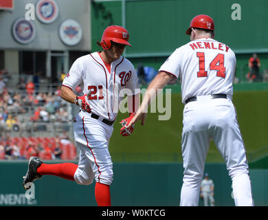 Washington Nationals pinch hitter Matt den Dekker is congratulated by thirdbase coach Bob Henley after he hit a game-winning two-run home run in the bottom of the eighth inning against the Los Angeles Dodgers at Nationals Park in Washington, DC on July 18, 2015.   Nationals won the July 17th suspended game 5-3.  Photo by Pat Benic Stock Photo