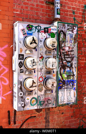 Multiple electric meter boxes covered in graffiti and stickers Stock Photo