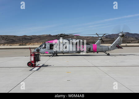 An MH-60S Sea Hawk helicopter assigned to the 'Black Jacks' of Helicopter Sea Combat Squadron (HSC) 21 is prepared on December 8, 2017, for flight to assist in fighting California fires. HSC-3 and HSC-21 are assisting California Department of Forestry and Fire Protection by providing aircrews flying specially-equipped MH-60S helicopters to conduct aerial water drops against wildfires in San Diego County. Photo by MC1 Paolo Bayas/U.S. Navy/UPI Stock Photo