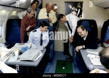 President Ronald Reagan is seen here in this November 16, 1985 file photo practicing his putting aboard Air Force One while en route to Geneva, Switzerland. Clockwise from left are: Major Tom Carter, the President's military aide; Robert McFarlane, then National Security Advise; Jim Kuhn, a presidential assistant; Thomas Dawson (partly hidden), an assistant to Donald Regan; Secretary of State George Schultz; White House Chief of Staff Donald Regan; the President, and Dennis Thomas, an assistant to Reagan. (UPI/File) Stock Photo