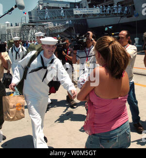 A Sailor greets his loved after departing USS Ronald Reagan (CVN 76) in San Diego, CA on July 23, 2004. The NavyÕs newest and most technologically advanced aircraft carrier is completing a two month transit from Norfolk, Va. Homeporting celebrations included  former First Lady Nancy Reagan, members of Congress, state officials and celebrities. The ship, commanded by Capt. James A. Symonds, was commissioned in July 2003. (UPI Photo/ PhotographerÕs Mate 2nd Class Brandon Teeples) Stock Photo