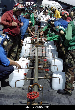 Crew members aboard USS Abraham Lincoln (CVN 72) fill jugs with purified water from a Potable Water Manifold on Jan. 10, 2005, in the Indian Ocean. The water jugs will be flown by Navy helicopters to regions isolated by the Tsunami in Sumatra, Indonesia.    (UPI Photo/Tyler J. Clements/US NAVY) Stock Photo