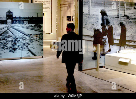 A visitor walks in front of a picture of death camp Auschwitz II-Birkenau at the Yad Vashem Holocaust Memorial's new museum in Jerusalem March 15, 2005. World leaders inaugurated a museum at Israel's Holocaust memorial on Tuesday in a show of international determination to keep alive the memory of the six million Jews killed by the Nazis and prevent future genocide.  (UPI Photo/Goran Tomasevic) Stock Photo