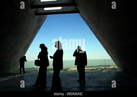 A security agent (R) and workers gather inside the exit area of the new Holocaust History Museum, that cuts through Mt. Herzl in Jerusalem and hangs over the mountain overlooking valleys and small towns to the west of jerusalem on Wednesday, 16 March 2004 as world leaders gather for the second day of events for the inauguration of the museum in the Yad Vashem Holocaust complex. Israeli architect Moshe Safdie designed the unusual museum that cost over 40-million dollars and took some ten years to construct, along with other building in the 100-million dollar complex.  (UPI Photo/Jim Hollander) Stock Photo