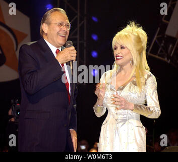 Secretary of Defense Donald H. Rumsfeld joins country music legend Dolly Parton on stage at the Grand Ole Opry during a live broadcast in Nashville, TN, on April 23, 2005.  Rumsfeld visited Nashville to thank Parton, the Grand Ole Opry, and the American people for their support of U.S. troops.  (UPI Photo/Cherie A. Thurlby/Air Force) Stock Photo