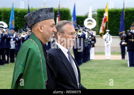 Secretary of Defense Donald H. Rumsfeld (right) escorts Afghan President Hamid Karzai to a full honors arrival ceremony welcoming Karzai to the Pentagon on May 23, 2005.  Karzai and his delegation met with Rumsfeld and his senior advisors for bilateral security discussions.   (UPI Photo/Robert  Ward/DOD)