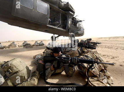 U.S. Army Soldiers from the 1st Brigade 1st Armored Division dismount a Blackhawk helicopter from the 101st Airborne Division during an Air Assault in the Al Jazeera Desert, Iraq on Mar 22, 2006. (UPI Photo/Staff Sgt. Aaron Allmon/DOD) Stock Photo