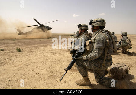 U.S. Army soldiers assigned to the 1st Brigade, 1st Armored Division wait to board a UH-60 Black Hawk helicopter during an air assault mission in the Al Jazeera Desert, Iraq on March 22, 2006.  DoD photo by Staff Sgt. Aaron Allmon, U.S. Air Force.  (Released) Stock Photo