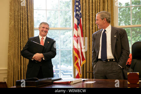 President George W. Bush shares a light moment with Chief of Staff Andrew Card in the Oval Office in this June 2005 file photo.  Tuesday, March 28, 2006, the President announced Secretary Card's resignation effective in April.  (UPI Photo/Eric Draper/White House) Stock Photo