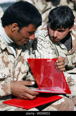 Two Iraqi soldiers from 2nd Brigade, 7th Iraqi Army Division look at their certificates of completion they received for finishing a three-week Humvee licensing and preventive maintenance course at Camp Al Asad, Iraq. More than 20 Iraqi soldiers graduated from the three-week course March 20, 2006, which was taught by Regimental Combat Team-7 Marines. The Iraqi soldiers are now fully qualified to train and license other soldiers within their command.    (UPI Photo/Staff Sgt. Jim Goodwin/USMC) Stock Photo