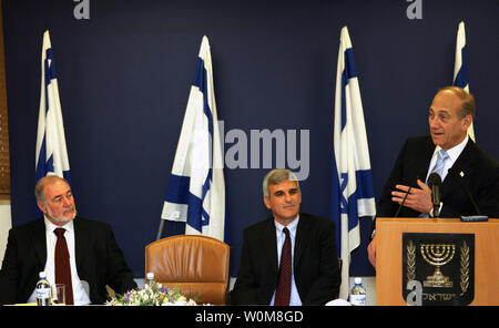 Israeli Prime Minister Ehud Olmert, right, speaks during an official ceremony to transfer the control of  the Finance Ministry in Jerusalem on May 7,  2006. The new Israeli 25-member cabinet was sworn in last week. At left is incoming Finance Minister Avraham Hirshzon and at center Yossi Bachar, Director General of the Ministry. (UPI Photo/Baz Ratner/ Pool) Stock Photo