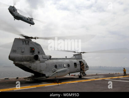 A CH-46 Sea Knight helicopter from Medium Helicopter Squadron 365 takes off as a second Sea Knight prepares to take off from the flight deck of the USS Iwo Jima (LHD 7) July 21, 2006. The multipurpose amphibious assault ship is currently part of a mission to assist U.S. citizens in their departure from Lebanon. (UPI Photo/Robert J. Fluegel/U.S. Navy) Stock Photo