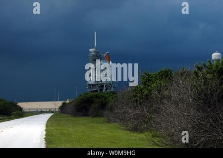 The dark clouds of a heavy rainstorm moving into Kennedy Space Center in the late afternoon on Sat., August 26, 2006, seem to illuminate the Space Shuttle Atlantis as it sits on Launch Pad 39B. A lightning strike to the pad's lightning protection system on August 25, caused the mission management team to postpone the launch of mission STS-115 for 24 hours in order to review all electrical systems on the space shuttle and ground support equipment at the pad. (UPI Photo/NASA/Ken Thornsley) Stock Photo