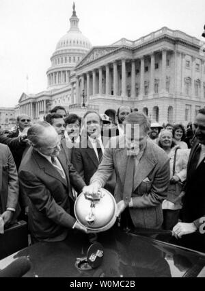 Charlton Heston died at the age of 84 at his home in Beverly Hills on April 5, 2008. He seen in this October 18, 1983 file photo (R-holding gas tank) with House Majority Leader Jim Wright D-Texas (L) pouring 'Methanol' into the actor's Corvette in front of the Capitol. Heston donated his 'Methanol' powered Corvette to the Renewable Energy Resources lobby group. (UPI Photo/Tim Clary/Files) Stock Photo