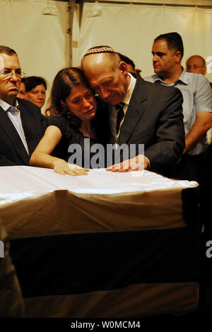 Israeli Prime Minister Ehud Olmert embraces Karnit Goldwasser, wife of Israeli soldier Ehud Goldwasser as they place hands on his coffin at Shraga army base near the northern Israel city of Nahariya on July 16, 2008. Lebanon's Hezbollah guerrillas released the bodies of Goldwasser and Eldad Regev in exchange for prisoners held by the Israelis. At left is Israel's Defense Minister Ehud Barak.  (UPI Photo/Avi Ohayon/GPO) Stock Photo