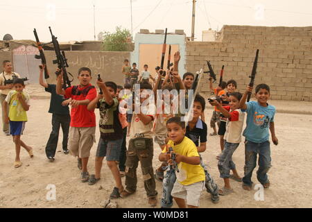 Iraqi boys play with toy guns to celebrate Eid al-Fitr in Baghdad, Iraq on October 3, 2008. Eid Al-Fitr, which celebrates the end of the holy month of Ramadan, is the most important date in the Muslim calendar.(UPI Photo/Ali Jasim) Stock Photo