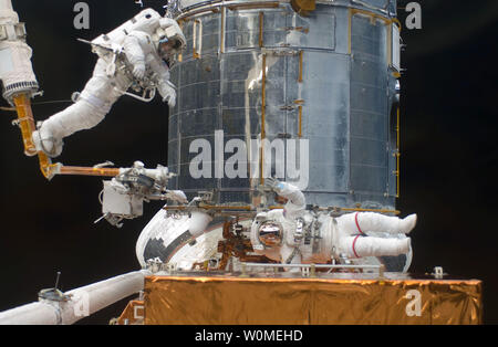 This NASA photo shows astronaut Andrew Feustel, STS-125 mission specialist, as he navigates near the Hubble Space Telescope on the end of the remote manipulator system arm, controlled from inside Atlantis' crew cabin, May 16, 2009. Astronaut John Grunsfeld signals to his crewmate from just a few feet away. Astronauts Feustel and Grunsfeld were continuing servicing work on the giant observatory, locked down in the cargo bay of the shuttle. (UPI Photo/NASA) Stock Photo