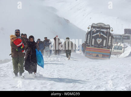 Victims of massive avalanches that occurred on February 8, 2010 in the mountains of Salang Pass, Afghanistan, head for safety on February 9, 2010, as an Afghan National Army Soldier provides assistance. More than 2,000 Afghans were rescued and rescue efforts were scheduled to continue through February 11.  Salang Pass links the Afghan Capital city of Kabul with the northern city of Mazar-i-Sharif.  UPI/Raflullah Mohibat/Afghan National Army Stock Photo