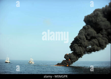 Dark clouds of smoke and fire emerge as oil burns during a controlled fire in the Gulf of Mexico on May 7, 2010. The U.S. Coast Guard working in partnership with BP PLC, local residents, and other federal agencies conducted the 'in situ burn' to aid in preventing the spread of oil following the April 20 explosion on Mobile Offshore Drilling Unit Deepwater Horizon.   UPI/Justin Stumberg/US Navy. Stock Photo