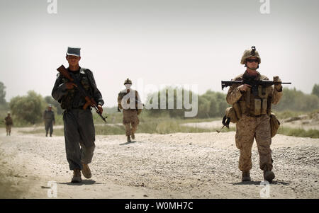 Sgt. Christopher Conaway (R), a squad leader with Kilo Company, 3rd Battalion, 3rd Marine Regiment, leads his squad and Afghan National Police officer partners on a brief patrol back to Patrol Base Jaker after manning a vehicle checkpoint as part of security for the Nawa District bazaar in Helmand province, Afghanistan on September 3, 2010. UPI/Mark Fayloga/U.S. Marines Stock Photo
