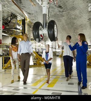 President Barack Obama, First Lady Michelle Obama, daughters Malia, left, Sasha, and Astronaut Janet Kavandi walk under the landing gear from beneath the nose of space shuttle Atlantis as they visit Kennedy Space Center in Cape Canaveral, Florida on April 29, 2011.   UPI/NASA/Bill Ingalls) Stock Photo