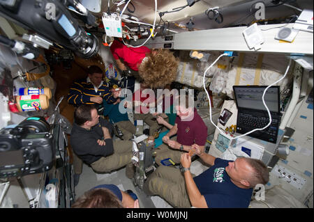 This NASA image taken on July 14, 2011 shows the seven astronauts, six from NASA and one from the Japan Aerospace Exploration Agency (JAXA), and three Russian cosmonauts as they eat a special meal on the Space Shuttle Atlantis' middeck. One of the final meals shared between shuttle and station crews has been called 'The All-American Meal.' The STS-135 crew consists of NASA astronauts Chris Ferguson, Doug Hurley, Sandy Magnus and Rex Walheim; the Expedition 28 or International Space Station crew members are JAXA astronaut Satoshi Furukawa, NASA astronauts Ron Garan and Mike Fossum, and Russian Stock Photo