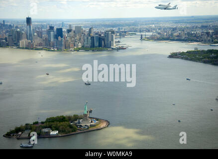 Space shuttle Enterprise, mounted atop a NASA 747 Shuttle Carrier Aircraft (SCA), is seen as it flies over the Statue of Liberty and the lower Manhattan skyline on Friday, April 27, 2012, in New York. Enterprise was the first shuttle orbiter built for NASA performing test flights in the atmosphere and was incapable of spaceflight. Originally housed at the Smithsonian's Steven F. Udvar-Hazy Center, Enterprise will be  placed on a barge that will eventually be moved by tugboat up the Hudson River to the Intrepid Sea, Air & Space Museum in June.    UPI/NASA/Robert Markowitz Stock Photo