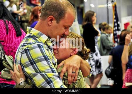 Army Spc. Jessie Nelson hugs her husband, Matt, on Joint Base Lewis-McChord, in Washington, July 10, 2013. Nelson and about 230 soldiers returned home after an eight-month deployment to Afghanistan to support Operation Enduring Freedom. Nelson is an all-source intelligence analyst assigned to the 2nd Infantry Division's Headquarters Company, 4th Stryker Brigade Combat Team.  UPI/Sgt. K. Hackbarth/DOD .. Stock Photo