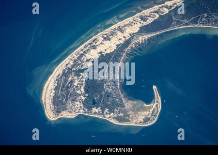 Astronauts aboard the International Space Station used a very long lens to shoot this detailed image of the northern tip of Cape Cod on June 13, 2015. Cape Cod is one of the biggest barrier islands in the world, and it protects towns like Provincetown and its port facilities (image center) from storm waves coming in from the Atlantic Ocean. It thus also protects much of the Massachusetts coastline. The cream-colored features are symmetrically shaped dunes built mainly by northwesterly winter winds (image upper center) blowing beach sands inland. NASA/UPI Stock Photo