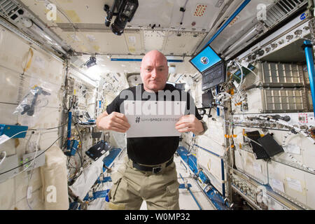 NASA astronaut Scott Kelly is photographed in the Japanese Experiment Module (JEM) holding a sign with the hashtag #WHYSPACEMATTERS on June 6, 2015. NASA and the United Nations Office for Outer Space Affairs (UNOOSA) have launched a global photography competition to highlight how the vantage point of space helps us better understand our home planet, improve lives, and safeguard our future by aiding sustainable development on Earth. ..Part of NASA's Human Research Program, the One-Year Mission on the International Space Station is a joint effort between the U.S. space agency, the Russian Federa Stock Photo