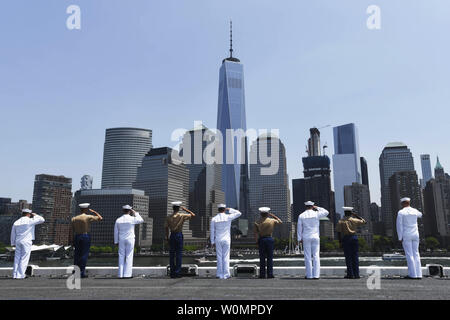 Sailors and Marines aboard the amphibious assault ship USS Bataan (LHD-5) salute One World Trade Center as the ship pulls in for 2016 Fleet Week New York on May 25, 2016. The event, now in its 28th year, is the city's time-honored celebration of the sea services. It is an unparalleled opportunity for the citizens of New York and the surrounding tri-state area to meet Sailors, Marines and Coast Guardsmen, as well as witness firsthand the latest capabilities of today's maritime services. The weeklong celebration has been held nearly every year since 1984. Photo by Mass Communication Specialist 1 Stock Photo