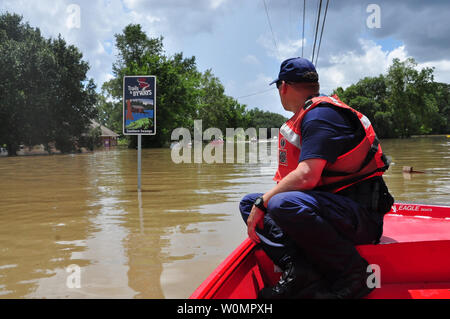 Petty Officer 1st Class Bradley Poen, a boatswain's mate assigned to Coast Guard Sector Lower Mississippi River, searches for people in distress in a flooded area of St. Amant, La., on August 16, 2016.  To date, Coast Guard crews have rescued more than 219 people, assisted more than 3,000 people in distress and rescued 57 pets. Photo by Melissa Leake/U.S. Coast Guard/UPI Stock Photo