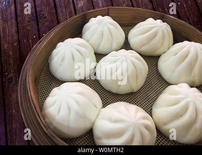 A cage of buns on a wooden table. Stock Photo